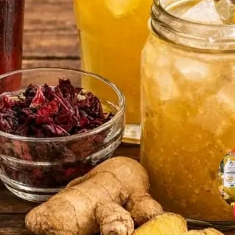 Rhizomes de gingembre frais posés près d'un bocal de boisson au gingembre